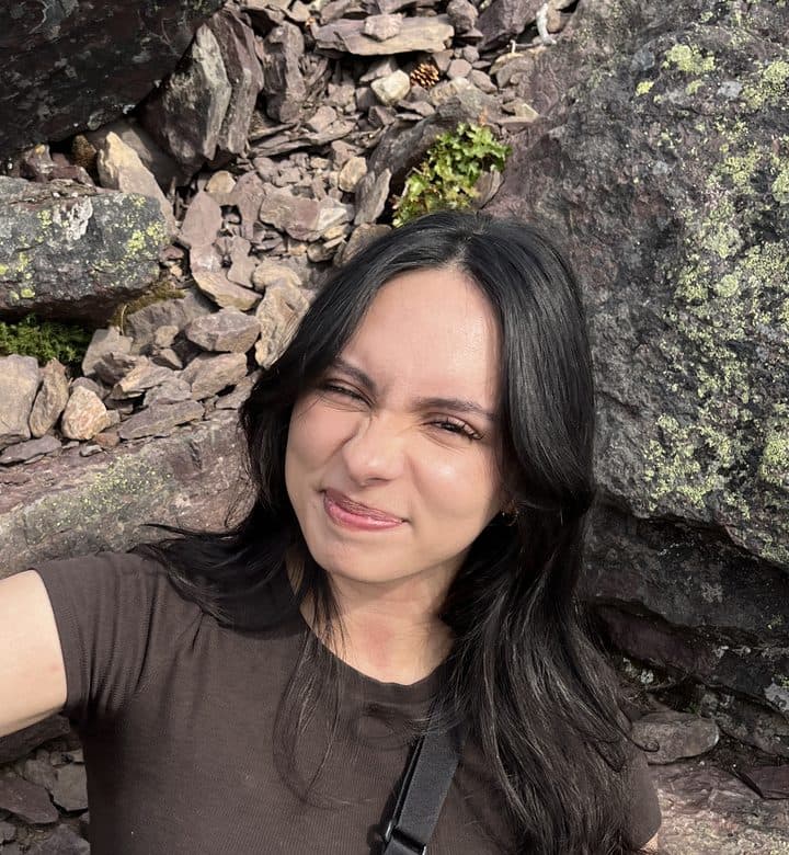 Noor smiling on a rocky hiking trail